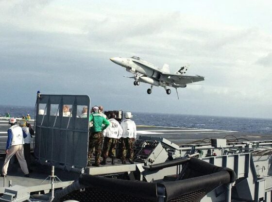 A fighter jet taking off from the deck of an aircraft carrier.
