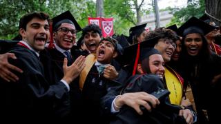 College students react as they receive their degrees during the 374th commencement ceremony at Harvard University.