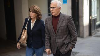 Baltasar Garzón and Dolores Delgado walking hand in hand through Madrid.