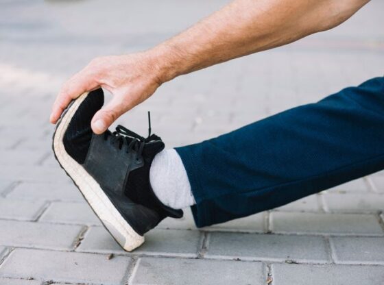 Sporty man stretching his foot on the alley Source: Freebeck