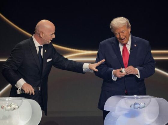 Gianni Infantino, President of FIFA, talks to US President Donald Trump as he draws during the FIFA World Cup 2026 Official Draw at John F. Kennedy Center for the Performing Arts on December 5, 2025 in Washington, DC.